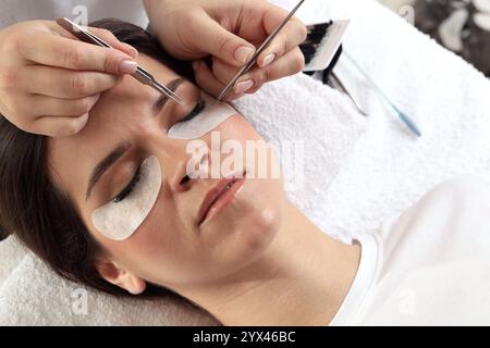 Donna sottoposta a procedura di estensione della Lash nel salone di bellezza, primo piano Foto Stock