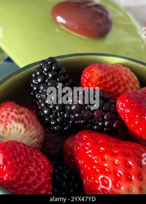 Fragole rosse fresche e gelso viola nella ciotola per mangiare Foto Stock