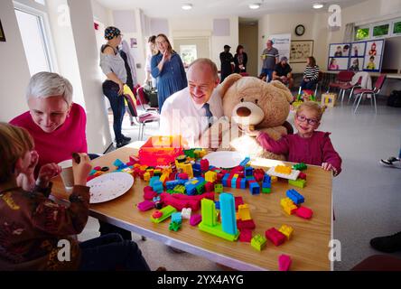 Sir ed Davey, leader liberale dei Democratici, con Alice Fry di tre anni (a destra) durante una visita all'associazione benefica Stepping Stones DS, che sostiene i giovani affetti da sindrome di Down e le loro famiglie, presso la WI Hall di Crookham Village, Fleet, Hampshire. Data foto: Venerdì 4 ottobre 2024. Foto Stock