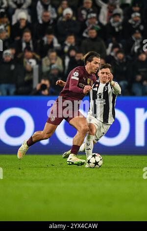 Jack Grealish di Manchester City si batte per la palla con Francisco Conceicao della Juventus durante la fase MD6 della UEFA Champions League 2024/25 Foto Stock