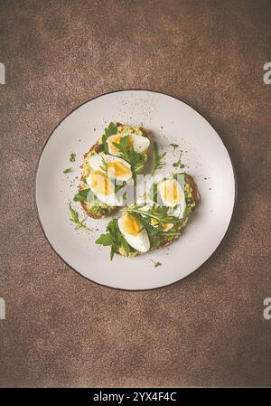 Panino con purè di avocado, uova sode e rucola, pane, fatti in casa, colazione Foto Stock