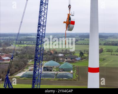 Assemblaggio di una turbina eolica Enercon e-138, lo statore, parte del generatore, viene trascinato alla navicella da una grande gru cingolata, il parco eolico Ahlen, Muens Foto Stock