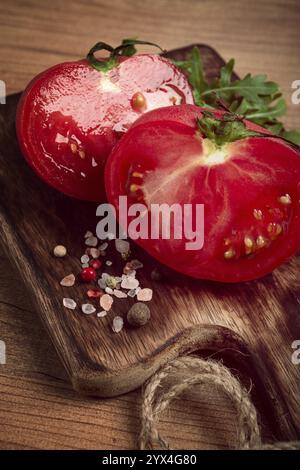 Pomodoro a fette, su un tagliere di legno, sottofondo alimentare, niente persone Foto Stock