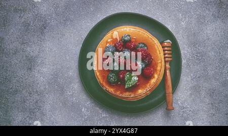 Colazione, pancake con frutti di bosco e miele, vista dall'alto, fatti in casa, niente persone Foto Stock