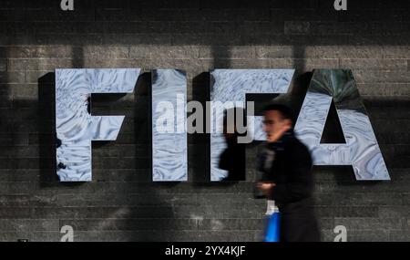 13 dicembre 2024, Svizzera, Zürich: Calcio: Qualificazione ai Mondiali Europa, un uomo passa davanti al logo FIFA sulla facciata del quartier generale FIFA dopo la cerimonia di sorteggio per le qualificazioni ai Mondiali 2026. Foto: Christian Charisius/dpa Credit: dpa Picture Alliance/Alamy Live News Foto Stock