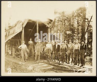 Ritratto di gruppo: Registratori, circa 1910-1930. Ritratto informale di gruppo di undici taglialegna che posano di fronte a una baracca con le loro attrezzature. Foto Stock