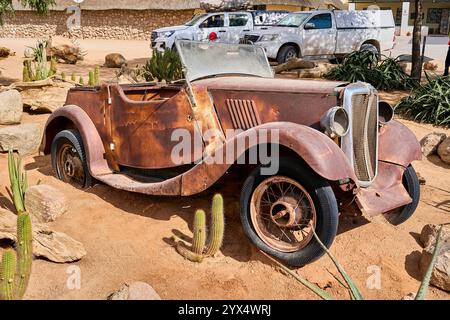 Una vecchia auto completamente arrugginita nella sabbia di un deserto, i relitti di Solitare, Namibia Foto Stock