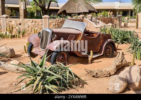 Una vecchia auto completamente arrugginita nella sabbia di un deserto, i relitti di Solitare, Namibia Foto Stock