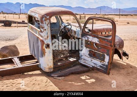 Guscio ruvido di un'auto vecchia, senza finestre, pneumatici a terra, relitti di auto di Solitare, Namibia Foto Stock