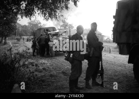 Russia 1943: Soldati tedeschi su un veicolo, dietro di loro bruciando case di villaggio nelle vicinanze dell'offensiva russa nella sezione centrale del fronte orientale (operazione Smolensk) e la ritirata tedesca nella regione di Zosh. Case e rifornimenti sono distrutti a causa dell'ordine della terra bruciata. Army Group Center, nell'area della 110th Infantry Division. [traduzione automatizzata] Foto Stock