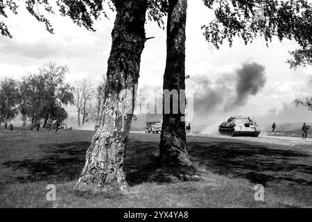 Russia 1944: Soldati tedeschi in fuga da un attacco russo vicino alla pista Mosca-Minsk. La foto è stata scattata durante i combattimenti dell'offensiva russa (operazione Bagration) nella sezione centrale del fronte orientale. Sulla destra della strada c'è un T34 russo catturato con una traversa. [traduzione automatizzata] Foto Stock