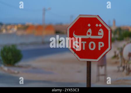 Segnale stradale DI STOP, in arabo, su sfondo sfocato Foto Stock