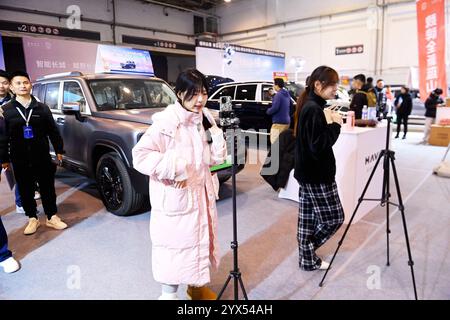 Qingdao, Cina. 13 dicembre 2024. Un'ancora trasmette in diretta al 16th Shandong International Auto Show 2024 a Qingdao, in Cina, il 13 dicembre 2024. (Foto di Costfoto/NurPhoto) credito: NurPhoto SRL/Alamy Live News Foto Stock