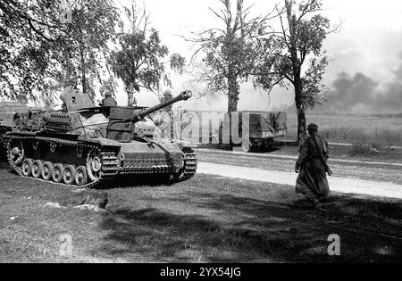 Russia, luglio 1944, operazione Bagration: Una pistola d'assalto e un camion sono mimetizzati sotto gli alberi vicino alla via di rullaggio Mosca-Minsk. [traduzione automatizzata] Foto Stock