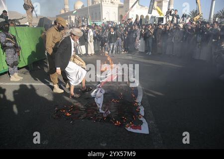 Sanaa, Yemen. 13 dicembre 2024. Le bandiere STATUNITENSI e israeliane bruciano durante una manifestazione di solidarietà con "il popolo di Gaza”, nel mezzo del conflitto in corso tra Israele e Hamas nella Striscia di Gaza. Crediti: Osamah Yahya/dpa/Alamy Live News Foto Stock