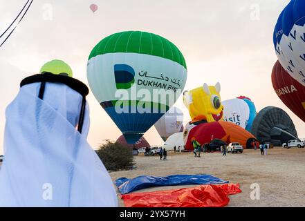 Doha, Qatar. 13 dicembre 2024. La gente guarda come le mongolfiere decollano durante il Qatar Balloon Festival 2024 a Doha, Qatar, il 13 dicembre 2024. La quinta edizione del Qatar Balloon Festival si svolge qui dal 12 al 22 dicembre e più di 50 partecipanti partecipano al festival. (Foto di Noushad Thekkayil/NurPhoto) credito: NurPhoto SRL/Alamy Live News Foto Stock