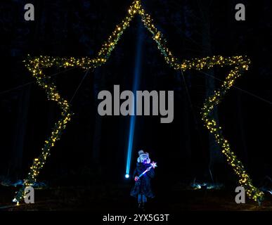 Beecraigs Country Park, West Lothian, Scozia, Regno Unito, 13 dicembre 2024. Starry Nights Illuminations: Il sentiero della foresta è illuminato da luci che i visitatori possono ammirare. Questa è la serata di apertura e il primo anno in cui questo evento ha avuto luogo in questo luogo. Nella foto: Naomi, di 5 anni, ama il sentiero. Crediti: Sally Anderson/Alamy Live News Foto Stock