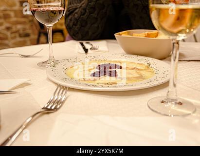 Torta del casar al formaggio. Formaggio al malto con marmellata di fragole accompagnato da vino e pane assaggiato. Foto Stock