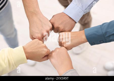 Lavoro di squadra. Gruppo di dipendenti che si uniscono per mano in ufficio, vista dall'alto Foto Stock