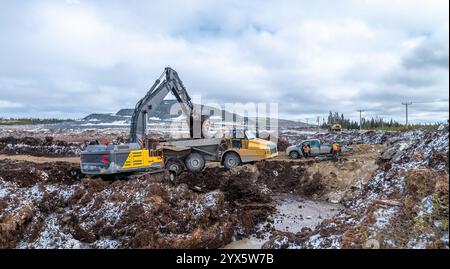 Scavo di torba con escavatore e dumper, in inverno Foto Stock