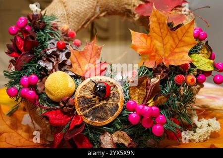 corona festiva di bacche, foglie e coni. Foto Stock