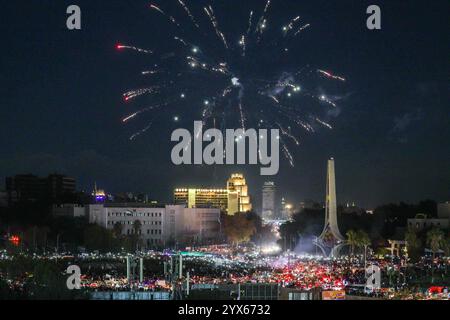 I fuochi d'artificio illuminano il cielo notturno mentre la gente si riunisce in Piazza Omayyad per celebrare il crollo del regime di Baath di 61 anni e la fine dell'era della famiglia Assad a Damasco, in Siria, il 13 dicembre 2024. Migliaia di giubilanti siriani si sono riuniti anche fuori da una moschea di riferimento nella capitale Damasco per celebrare durante le preghiere del primo venerdì dall'estromissione di Assad l'8 dicembre. Foto di Omar Haj Kadour/UPI credito: UPI/Alamy Live News Foto Stock