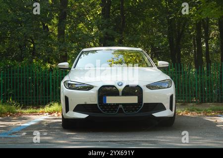 Bucarest, Romania - 22 luglio 2024: BMW i4 edrive40 auto elettrica bianca parcheggiata nel parcheggio di fronte al recinto del parcheggio Foto Stock