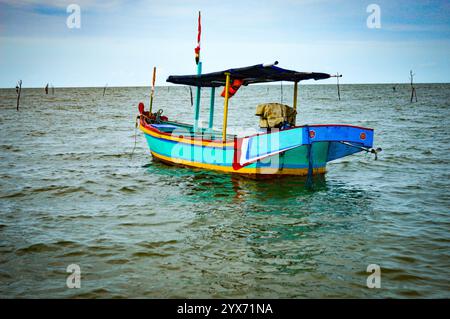 Tradizionale barca in legno di proprietà di pescatori indonesiani in mezzo al mare. Concentrarsi su barca, rumorosa, esposizione, altri simili Foto Stock