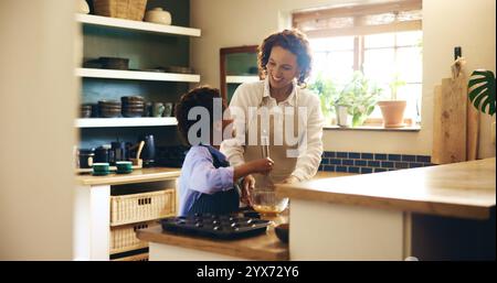 Cuocere, legare e bambini con la madre in cucina per sviluppare le proprie abilità con i cupcake al cioccolato. Insegnare, imparare e cucinare biscotti per bambini Foto Stock