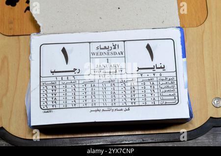 Cairo, Egitto, 11 dicembre 2024: Calendario di impiccagione giornaliero con blocco gregoriano e Hijri in lingua araba dell'anno 2025, 1 gennaio 2025 Gregoriano, Rajab Foto Stock