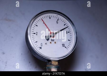 Manometro, manometro per misurare la pressione del gas. Manometro, manometro, attrezzatura tecnica nel seminterrato. Dispositivo analogico per misurare la pressione del gas. Obj gauge manometro B97A8111 Foto Stock