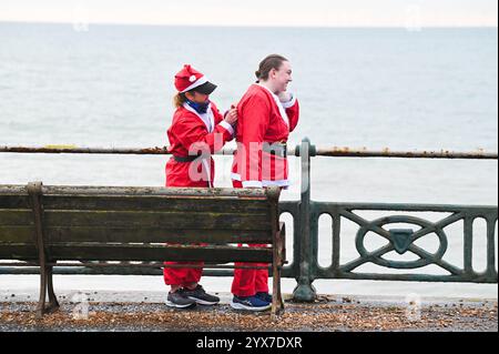 Brighton Regno Unito 14 dicembre 2024 - prepararsi per quest'anno Brighton Santa Dash lungo il lungomare di Hove raccogliendo fondi per la Rockinghorse ChildrenÕs Charity in una mattinata fresca e noiosa lungo la costa meridionale : Credit Simon Dack / Alamy Live News Foto Stock