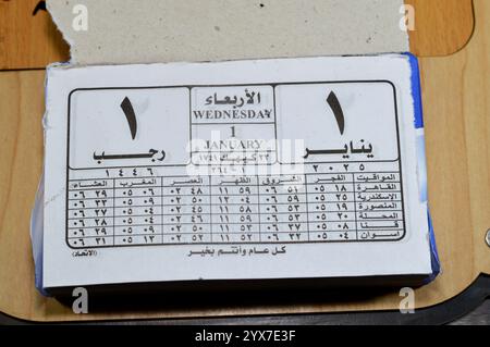 Cairo, Egitto, 11 dicembre 2024: Calendario di impiccagione giornaliero con blocco gregoriano e Hijri in lingua araba dell'anno 2025, 1 gennaio 2025 Gregoriano, Rajab Foto Stock