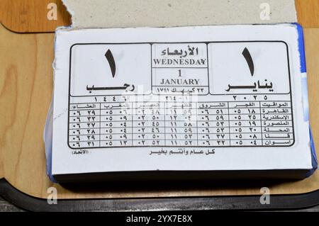 Cairo, Egitto, 11 dicembre 2024: Calendario di impiccagione giornaliero con blocco gregoriano e Hijri in lingua araba dell'anno 2025, 1 gennaio 2025 Gregoriano, Rajab Foto Stock