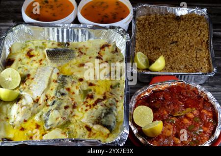Pasto a base di pesce di triglia al forno con salsa bianca cremosa, pezzetti di patate, riso di pesce rosso, gamberetti al forno con salsa rossa e frutti di mare c Foto Stock