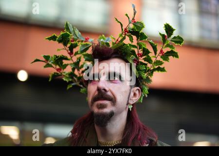 Una persona vestita da Babbo Natale prima di prendere parte alla parata natalizia di London Santacon al Floating Pocket Park di Londra. Data foto: Sabato 14 dicembre 2024. Foto Stock