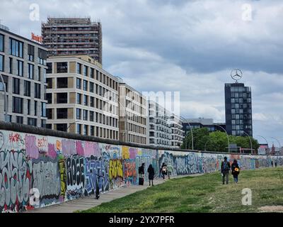 Ufficio vendite Mercedes-Benz Germania con logo/stella Mercedes in alto dietro il muro di Berlino Foto Stock