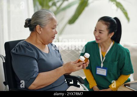 Donna anziana che prende pillole dal Dottore Foto Stock