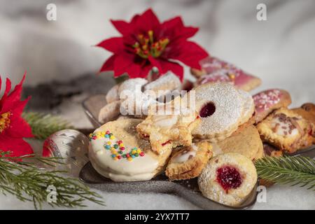 Biscotti su un piatto, accompagnati da punta rossa e rami di abete Foto Stock