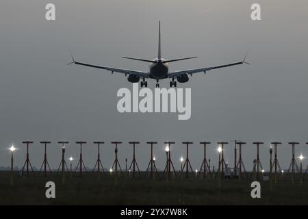 Boeing 737 aerei da passeggeri in avvicinamento per atterrare al tramonto sopra i fari di atterraggio, aeroporto di Londra Stansted, Essex, Inghilterra, Regno Unito, Europa Foto Stock