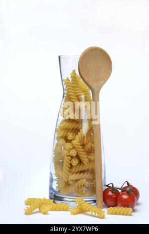 Pasta, varietà "Fusili" in contenitore di vetro con cucchiaio da cucina Foto Stock