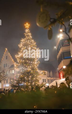 Grande albero di Natale illuminato nel mezzo di una folla di notte, mercatino di Natale, Nagold, Foresta Nera, Germania, Europa Foto Stock