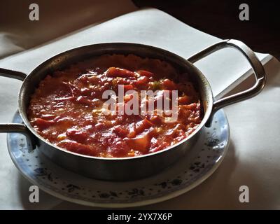Una porzione di Menemen, un piatto tradizionale turco, consiste di uova strapazzate cotte con pomodori, peperoni, cipolle e formaggio Foto Stock