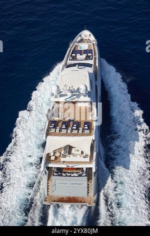Immagine aerea di un lussuoso yacht a motore che viaggia attraverso le tranquille acque dell'oceano in piena luce del giorno Foto Stock