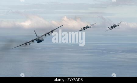 Un C-130 H2 Hercules della Missouri Air National Guard e due 25th Fighter Squadron A-10 Thunderbolt IIS volano in formazione sopra il Mar delle Filippine, 12 dicembre, Foto Stock