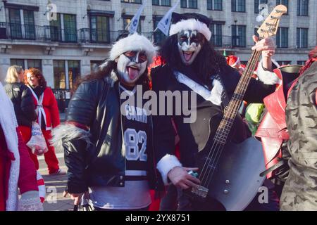 Londra, Regno Unito. 14 dicembre 2024. I rivelatori vestiti da rock band KISS partecipano al Santacon di quest'anno. Ogni anno, centinaia di festaioli vestiti da Babbo Natale fanno un giro dei pub nel centro di Londra. Crediti: Vuk Valcic/Alamy Live News Foto Stock