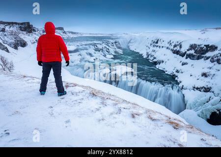 Una persona che ammira le cascate di Gullfoss in inverno all'alba. Hrunamannahreppur, Árnessýsla, Suðurland, Islanda, Nord europa. Foto Stock