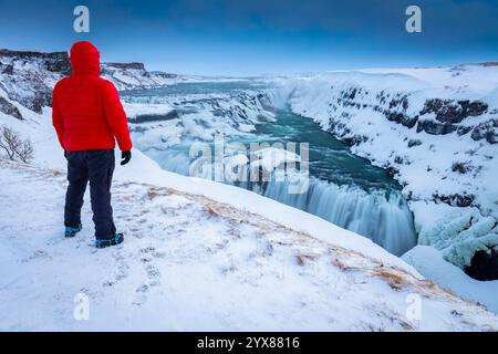Una persona che ammira le cascate di Gullfoss in inverno all'alba. Hrunamannahreppur, Árnessýsla, Suðurland, Islanda, Nord europa. Foto Stock
