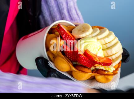 Waffle di Hong Kong nelle mani di un venditore Foto Stock