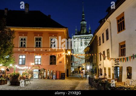 La città vecchia medievale Sighișoara di notte guardando verso la Torre dell'Orologio da Piata Cetatii (Piazza della Cittadella), Transilvania, Romania Foto Stock